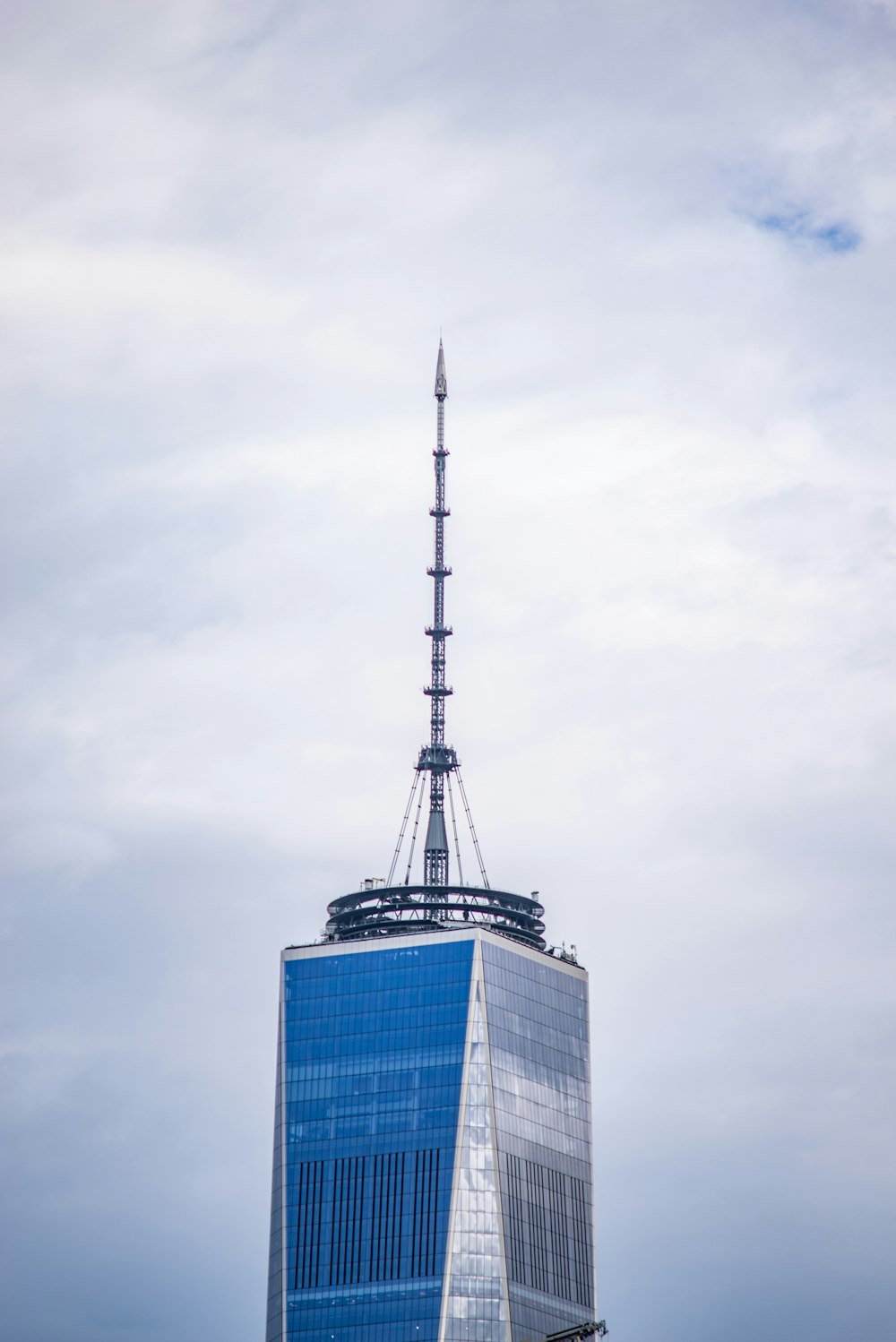 grey communication tower on top of blue and grey building