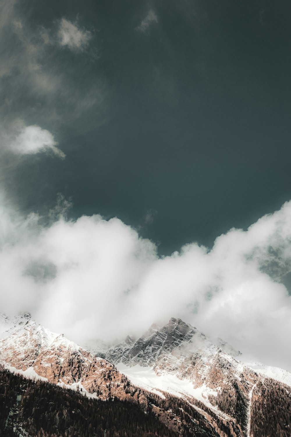 a snow covered mountain under a cloudy sky