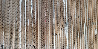 Stack of brown corrugated cardboard sheets neatly arranged on a wooden table