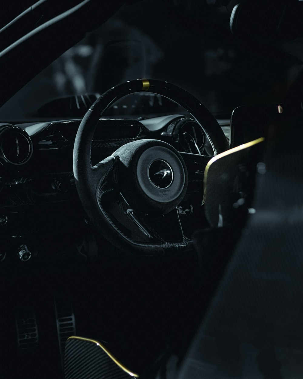 close-up photography of black vehicle steering wheel during nighttime