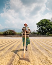 woman standing while holding spreading stick near tree