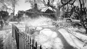 Snow plowing service clearing a driveway of an upscale home during a fresh snowfall.