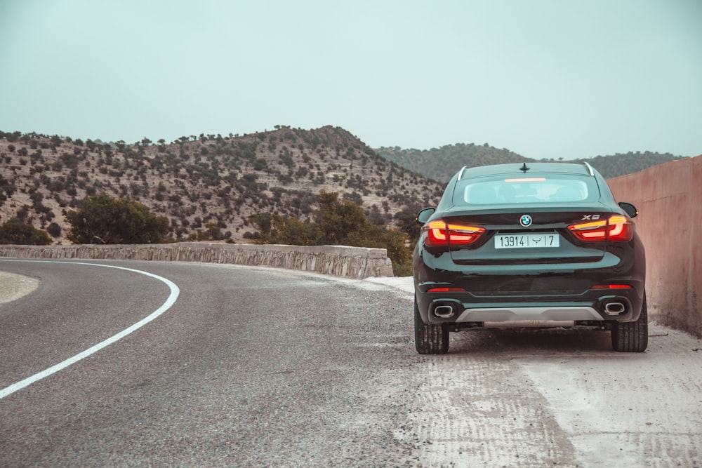 black BMW X6 parked on roadside with taillights turned on