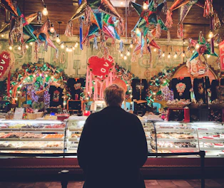 A vibrant bakery storefront decorated for a community event, attracting a crowd of happy customers.