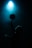 A silhouette of a person balancing a basketball on their finger under a dramatic blue spotlight, creating a mysterious and focused atmosphere.