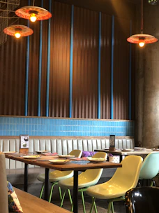 A warm, inviting dining area with red and golden yellow accents and customers enjoying fresh meals.