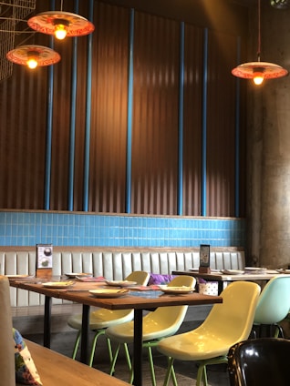 A cozy, inviting restaurant interior with warm lighting and a rustic wooden table set with a colorful chicken and rice dish.