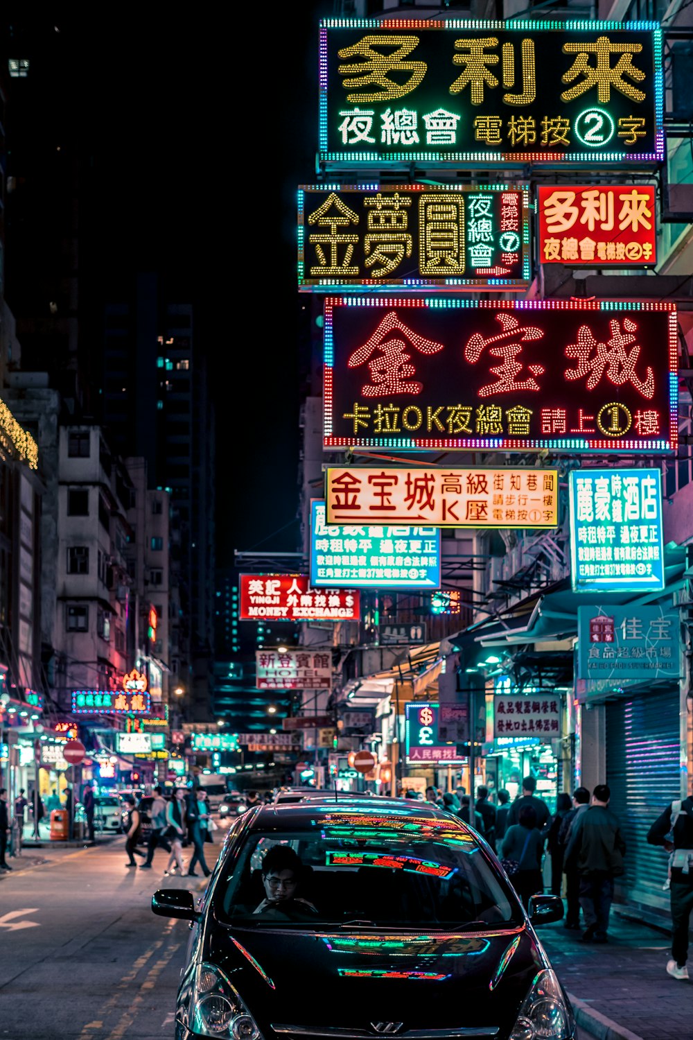 black vehicle parked beside building with turned-on Kanji script neon signs during night