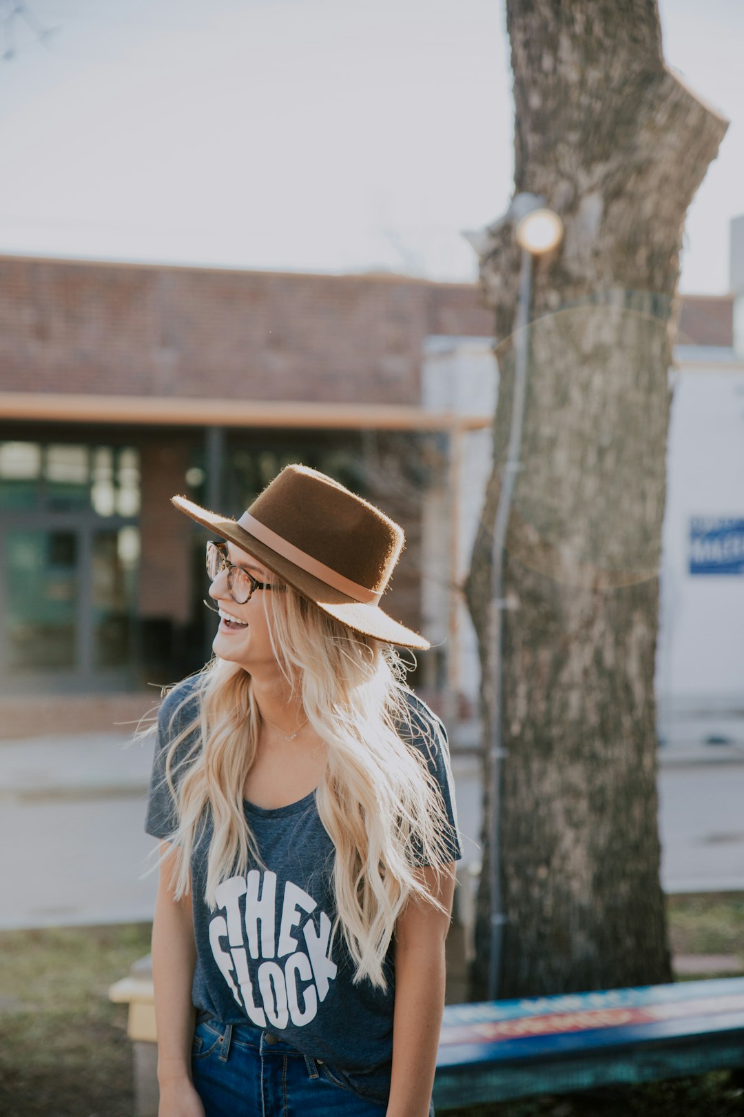 woman standing near bench beside tree