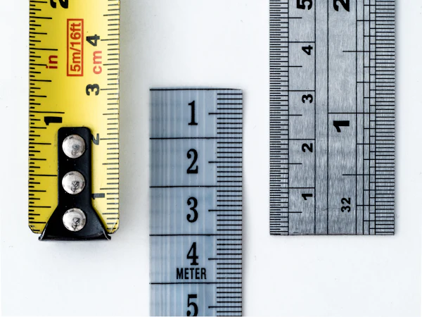 An array of measuring rulers and tape measures laid side by side