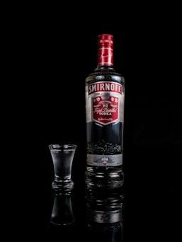 Smirnoff vodka bottle besides shot glass