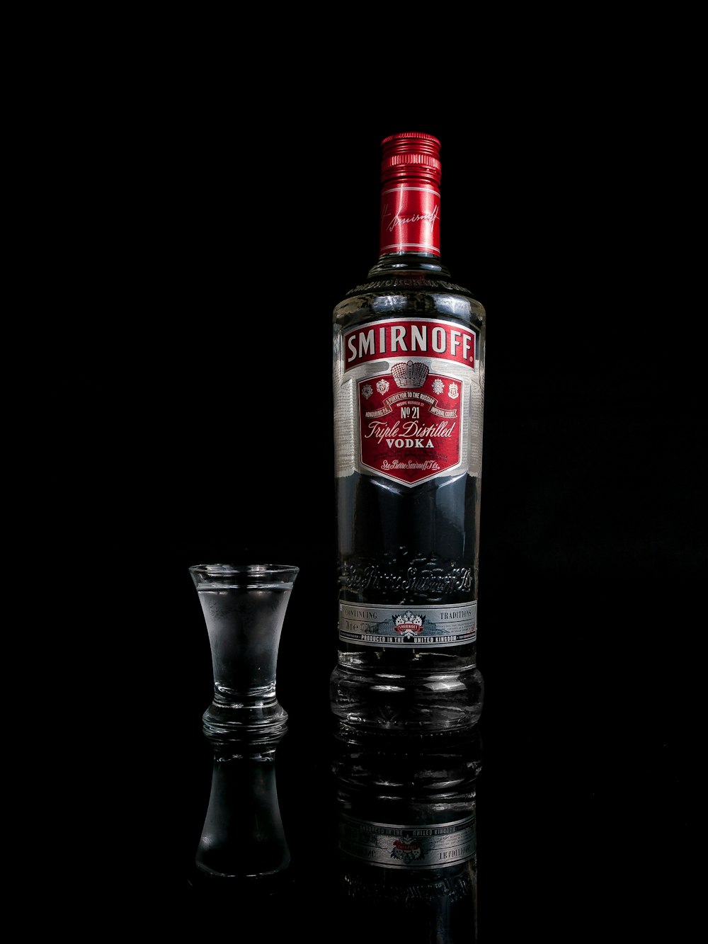 Smirnoff vodka bottle besides shot glass