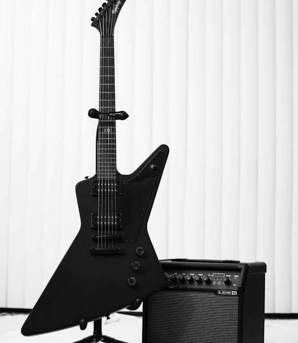 black electric guitar and amplifier