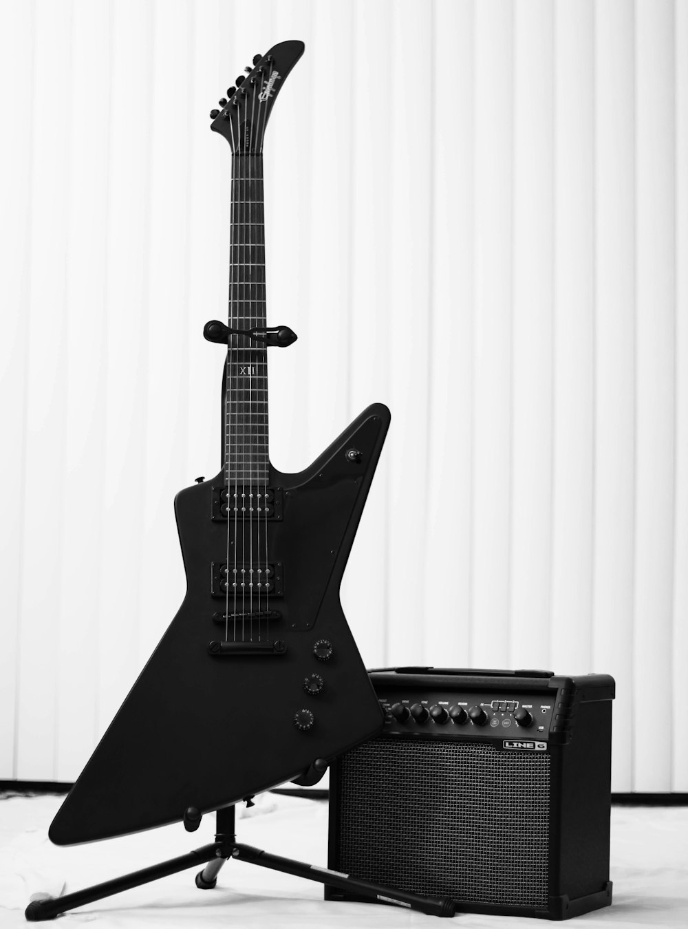 Guitarra eléctrica negra y amplificador