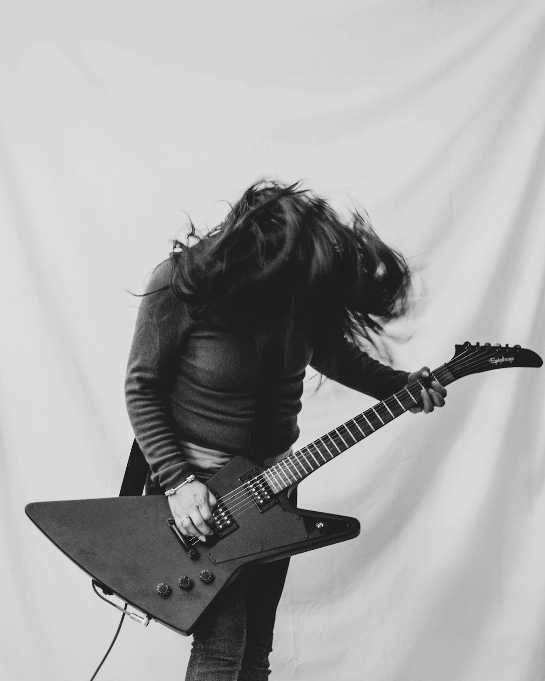 Female guitarist performing with an angular guitar