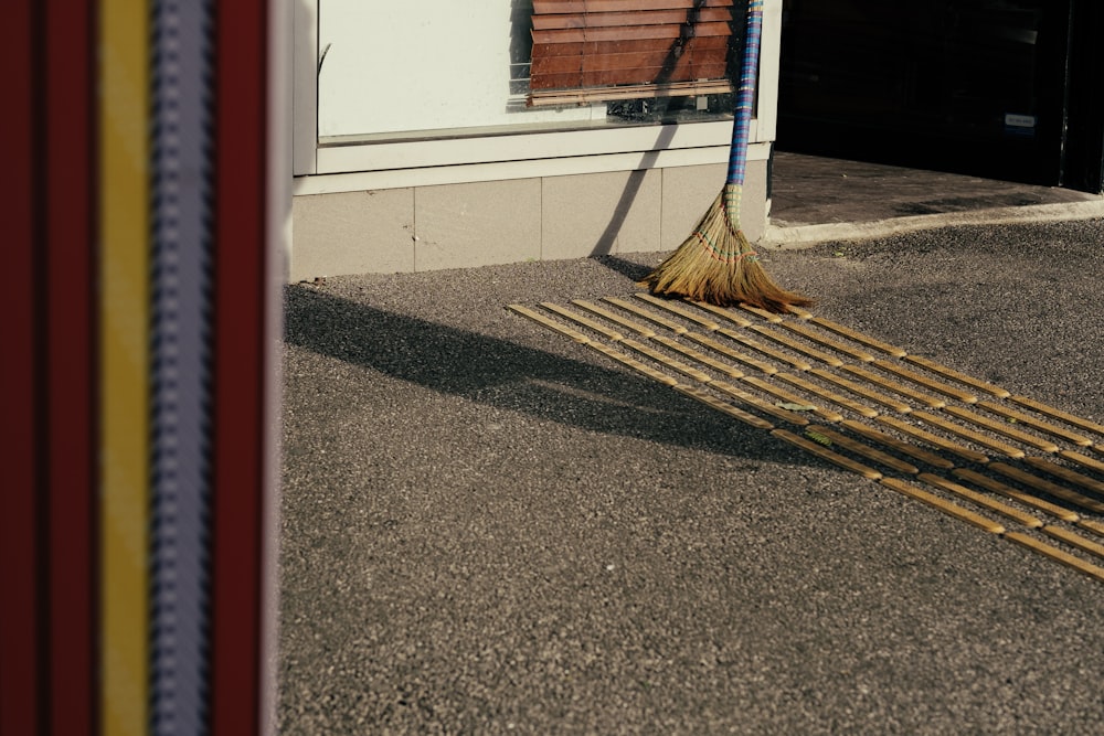 brown broom on gray concrete pavemebt