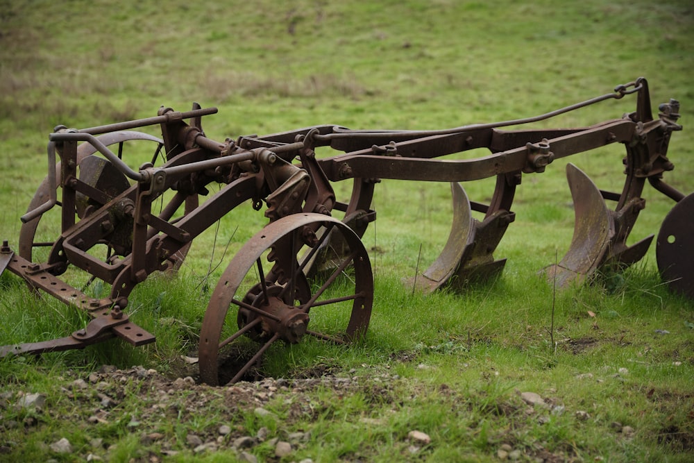 brown harrow disc on grass field