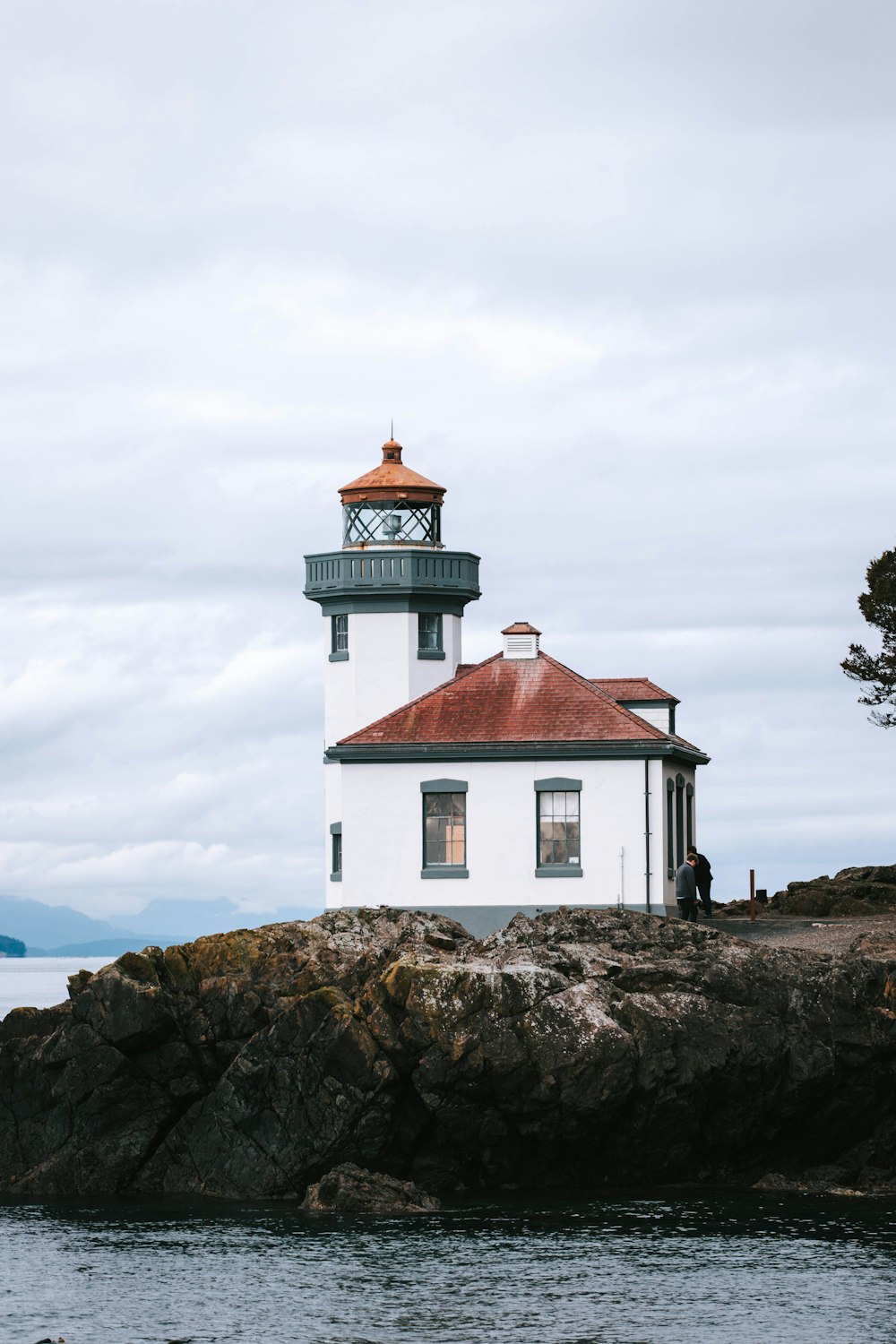 white and brown lighthouse near body of water during daytime