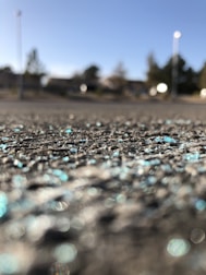 Bright, colorful glitter particles floating over a scenic outdoor background through a phone camera.