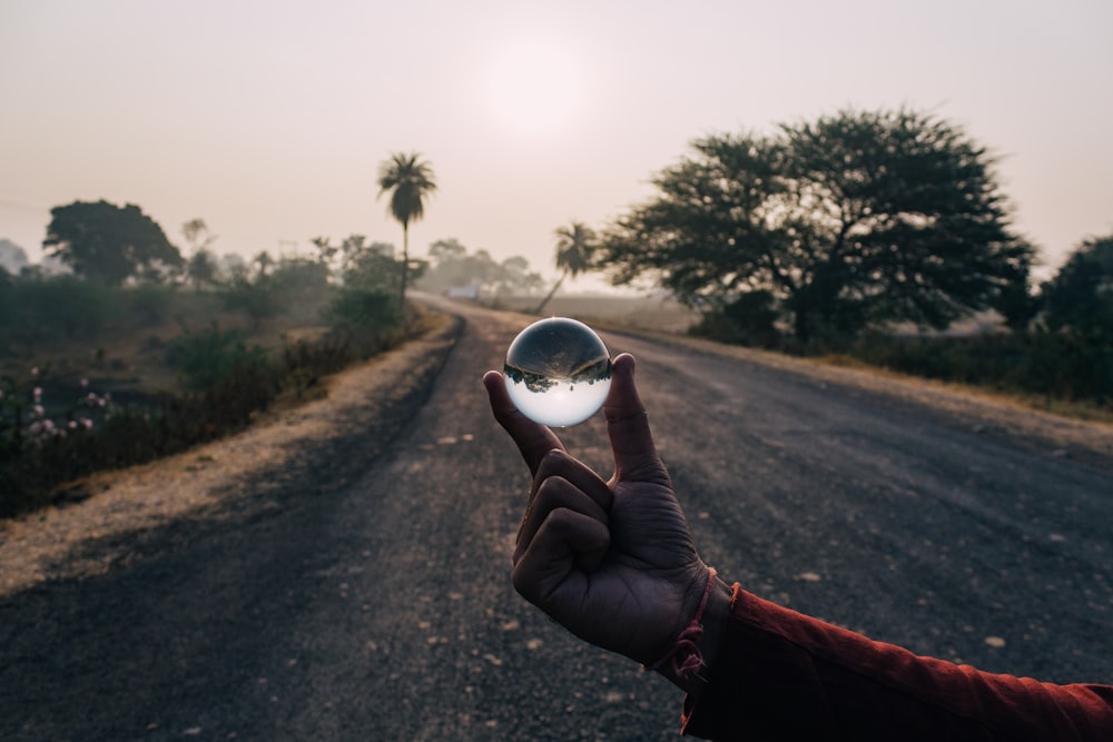 person holding clear ball decor