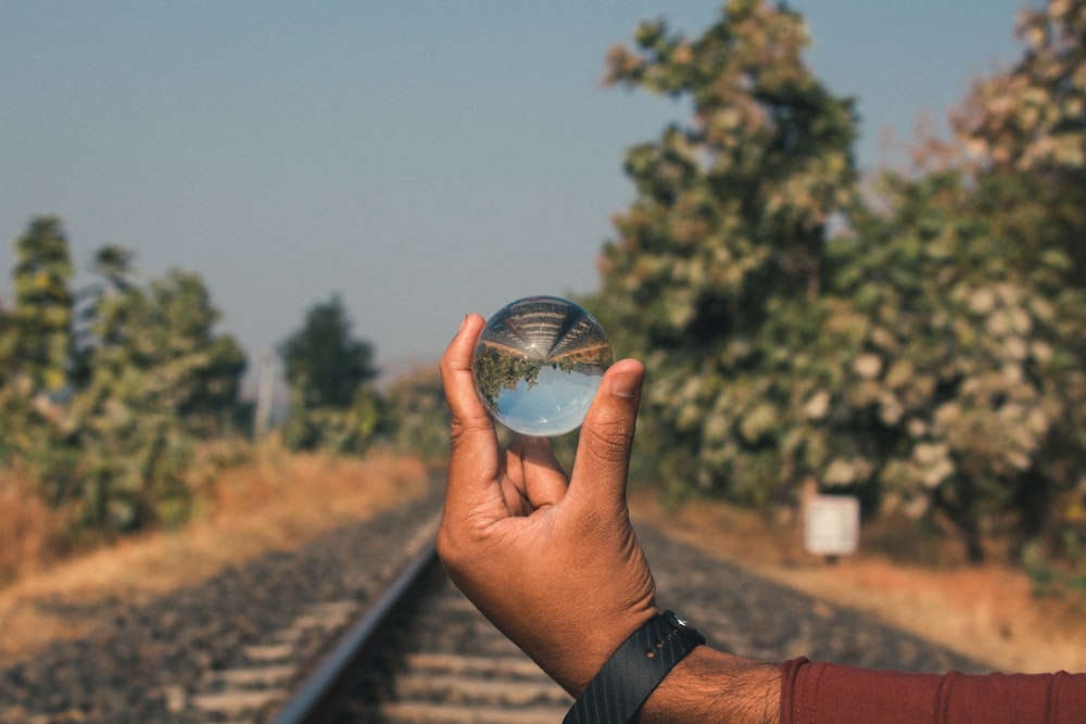 person holding white glass orb