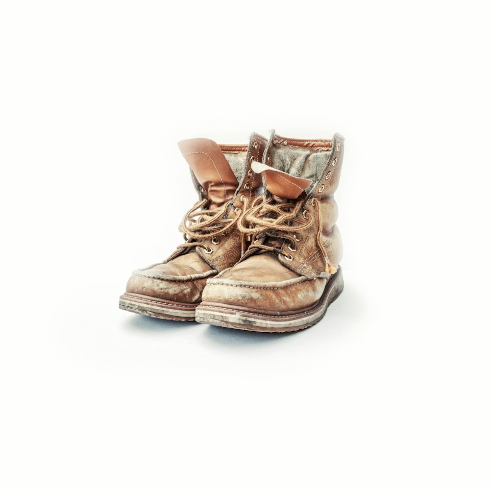 paire de chaussures à lacets en cuir marron sur surface blanche