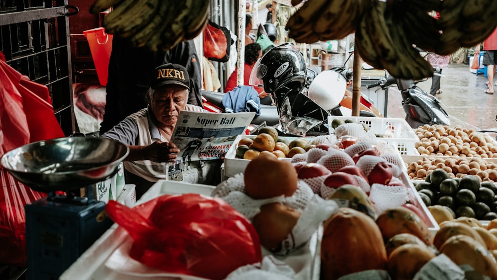 man reading newspaper with stalls