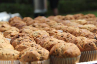 An assortment of colorful muffins arranged on a wooden board, each bursting with berries or chocolate chips.