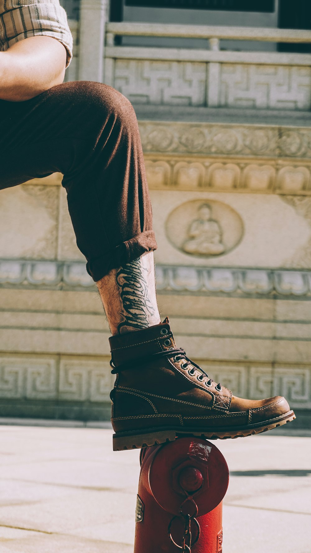 man wearing brown lace-up shoe near brown surface