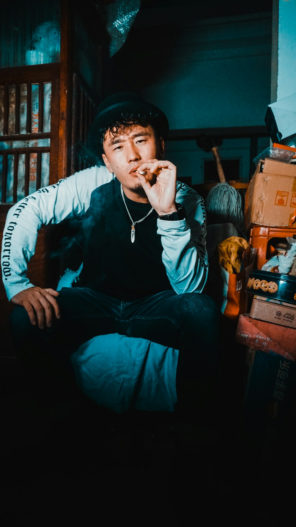 man smoking cigarette while sitting on chair