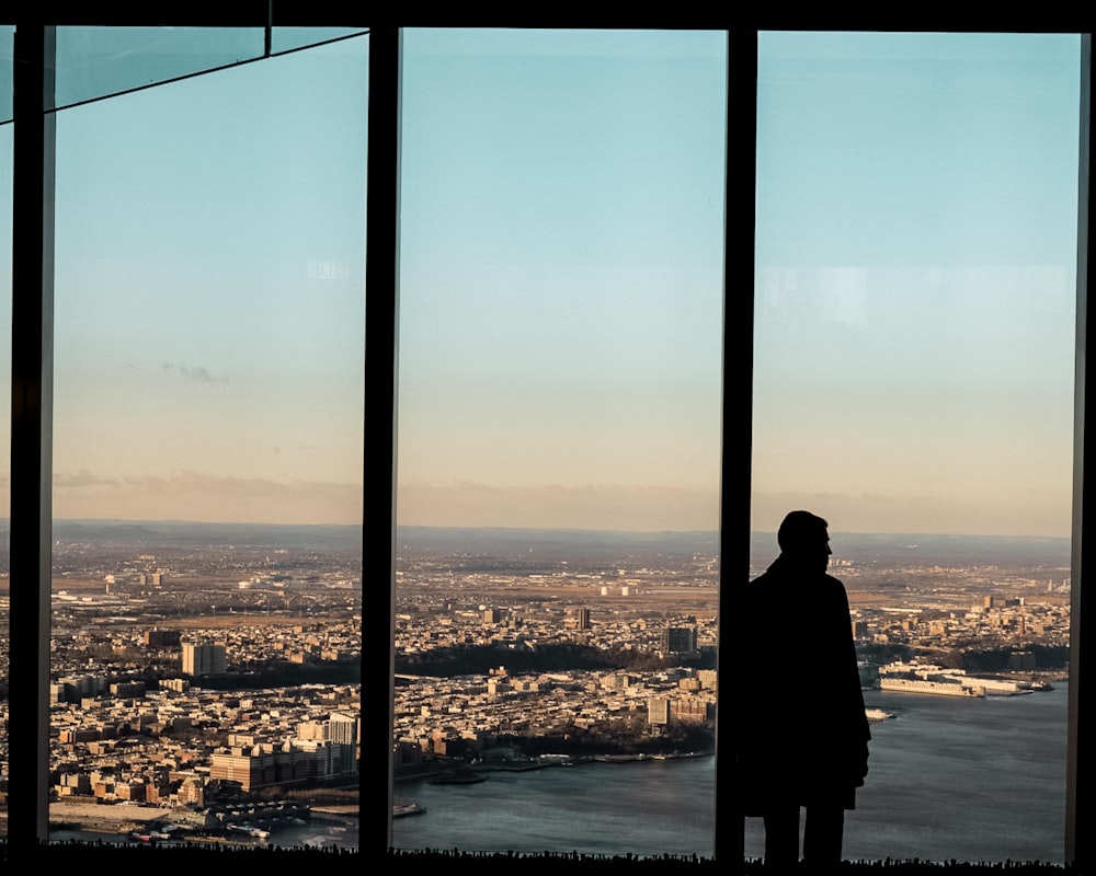 man standing beside glass wall