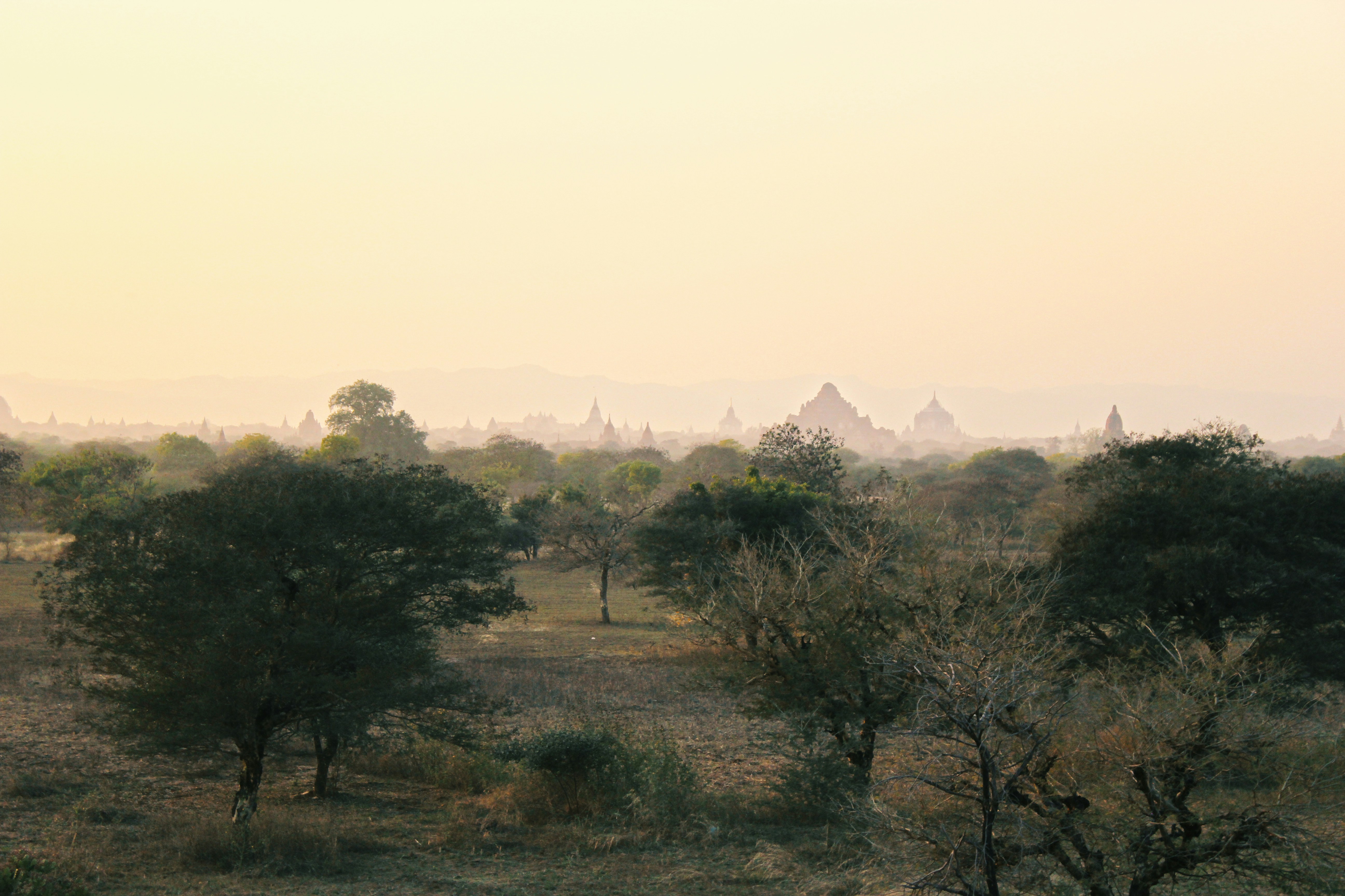 Thousands of ancient pagodas in misty Bagan plains, golden dawn light, deep atmospheric haze, spiritual landscape