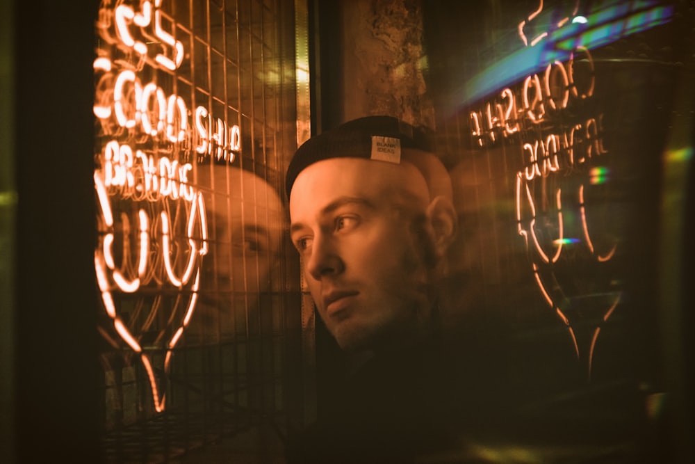 man stands near neon sign