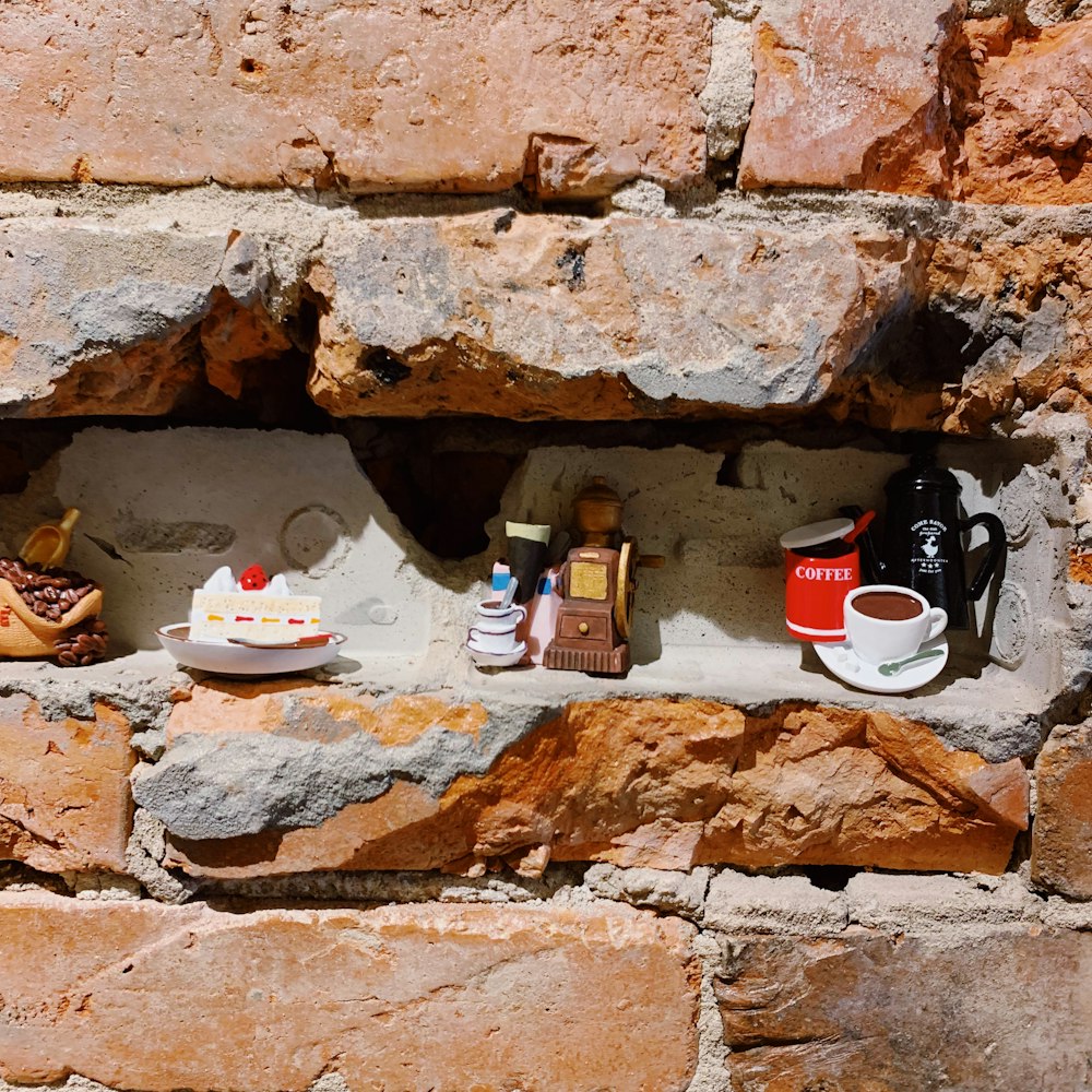 a brick wall with a cup of coffee and a cake on it