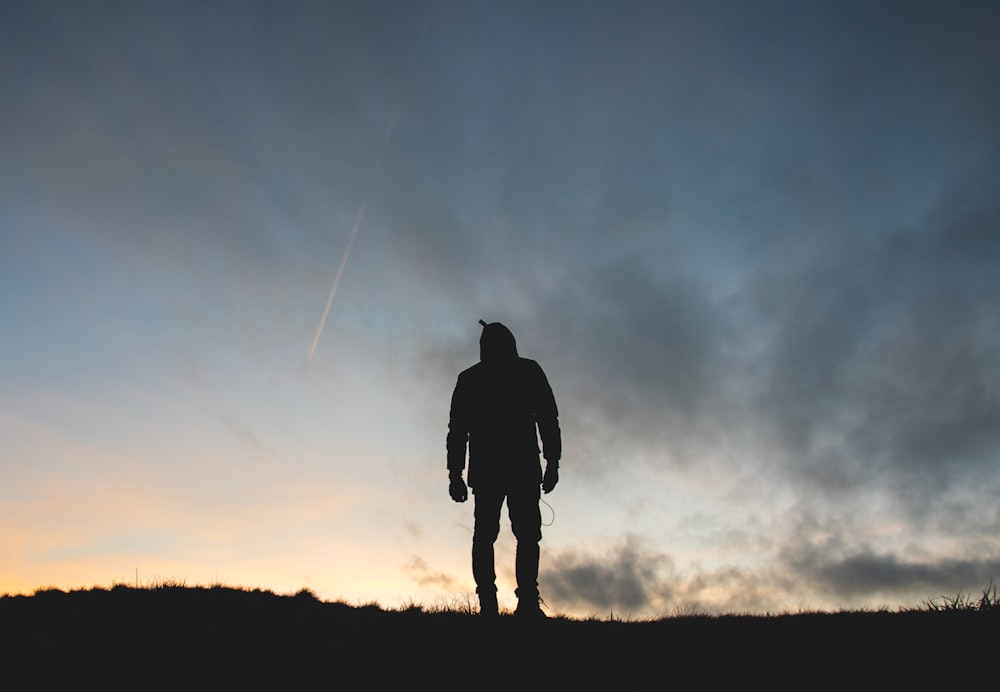 silhouette of person across clouds