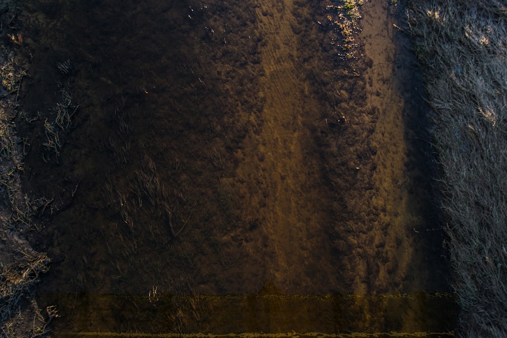 an aerial view of a dirt field with a yellow line in the middle