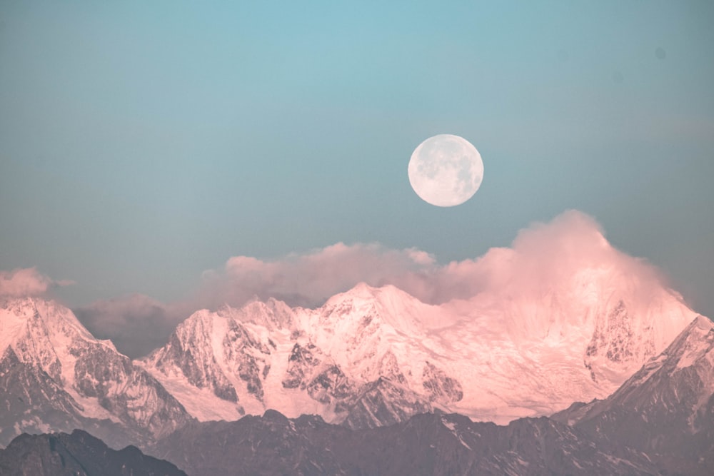 moon over snow covered mountains