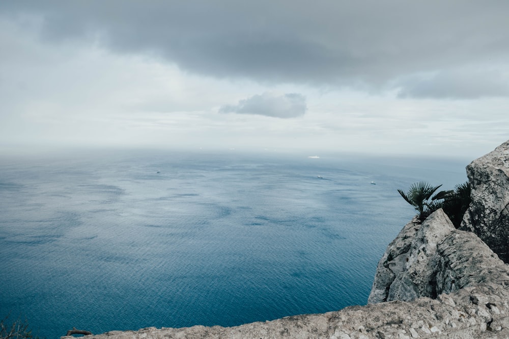 calm sea under gray clouds at daytime