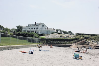 people lying and sitting on sand beside gray chain link fence during daytime rhode island google meet background