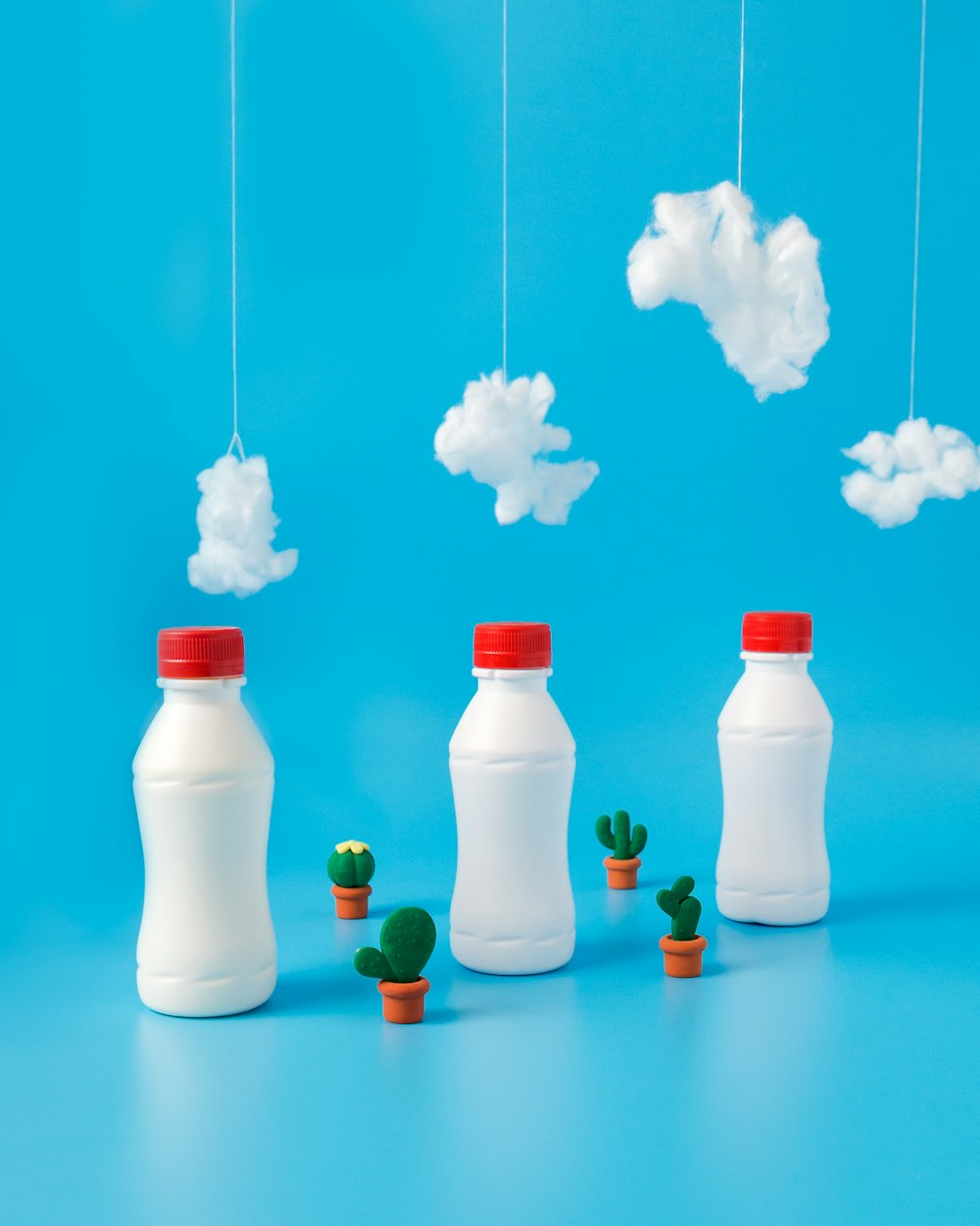 tre bottiglie di plastica bianche sotto cotoni bianchi