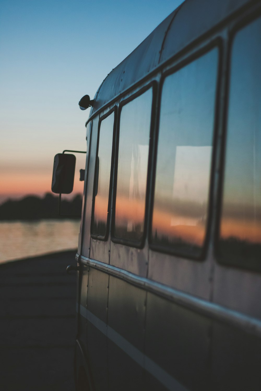 gray vehicle traveling on road during sunset