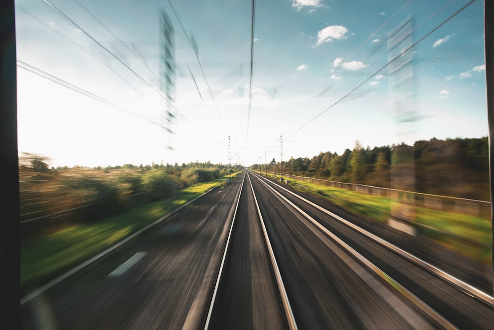 uma vista de um trilho de trem de um trem em movimento