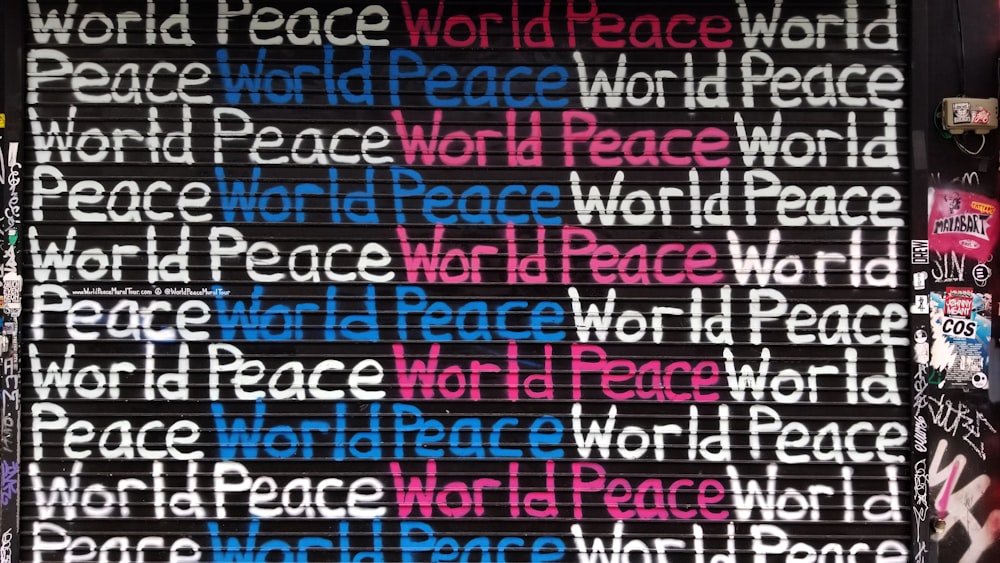 white, blue, and pink world peace painted wall