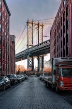 cars parked on both sides of street near bridge