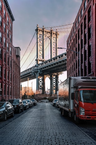 cars parked on both sides of street near bridge