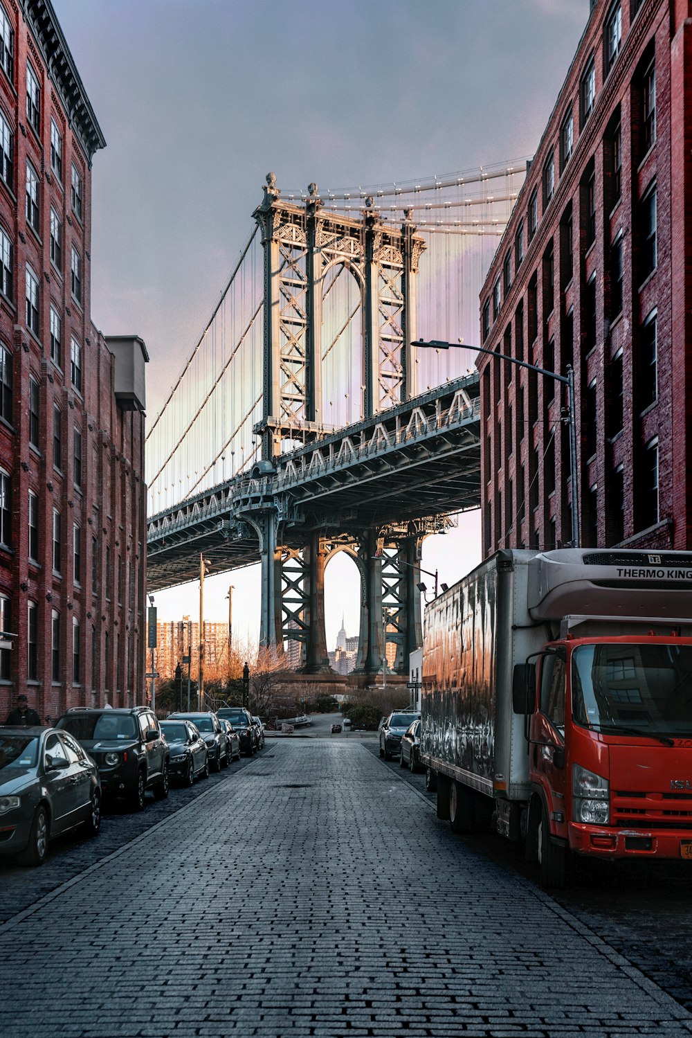 cars parked on both sides of street near bridge