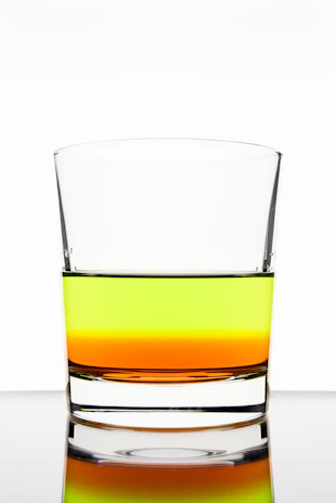 Colorful liquids layered in a transparent container demonstrating density differences.