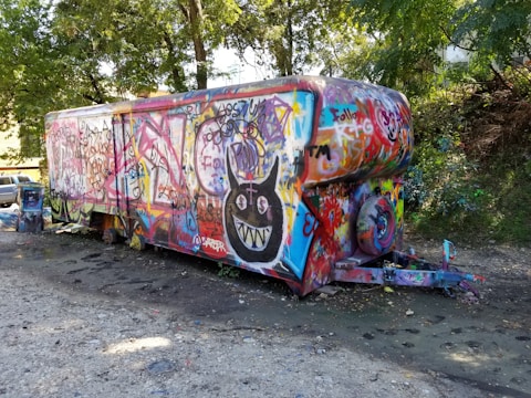 A colorful mobile art trailer parked at a vibrant outdoor event.
