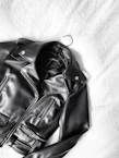 black leather zip-up jacket on white textile