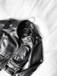 black leather zip-up jacket on white textile